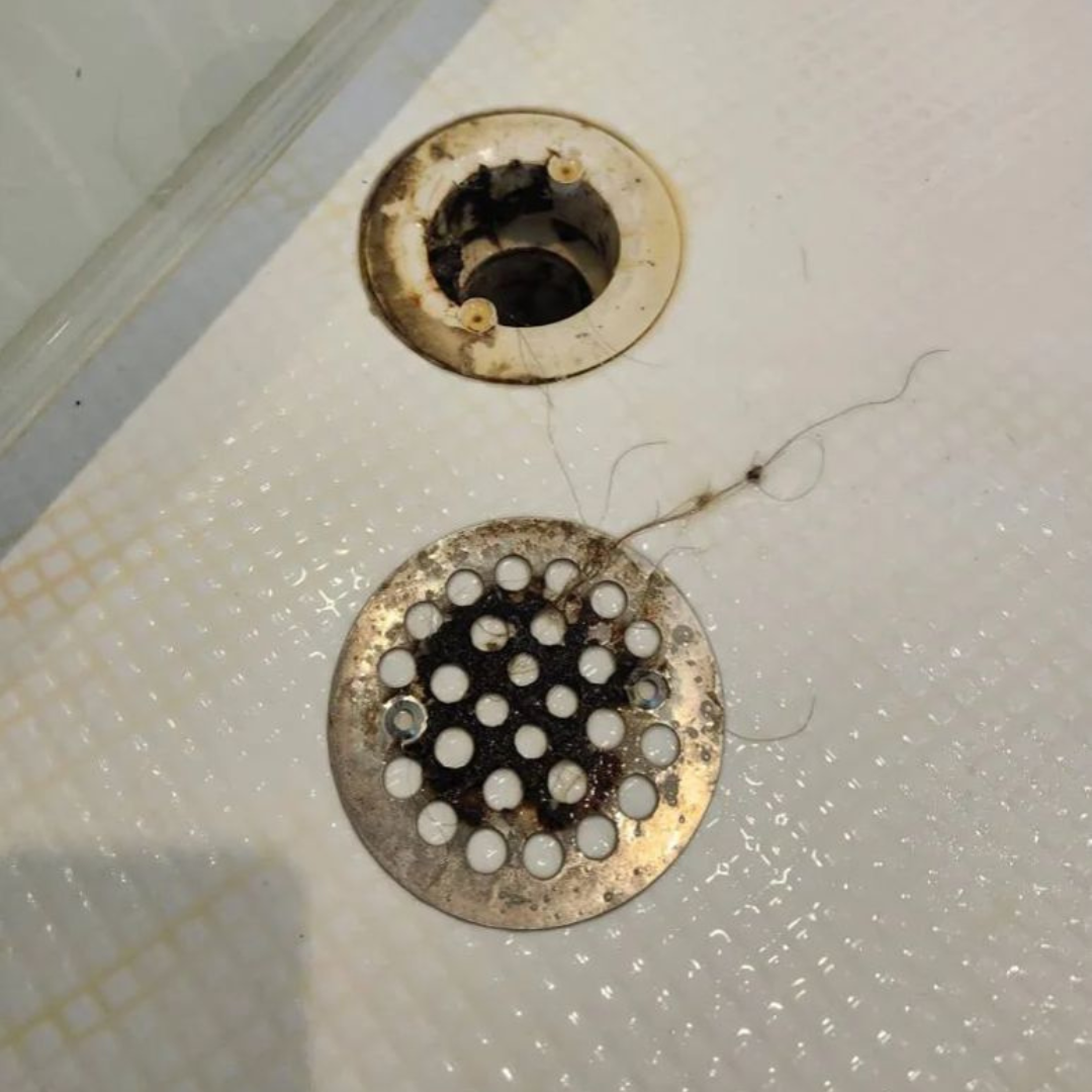 Professional cleaning in Somerville, MA Bathroom floor drain with buildup before professional cleaning in Somerville, MA